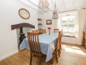 una sala da pranzo con tavolo, sedie e camino di Oak Cottage a Plymouth