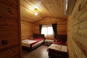 a room with two beds in a log cabin at mercan pension in Olympos