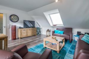 a living room with a couch and a tv at Louise am Meer in Norderney