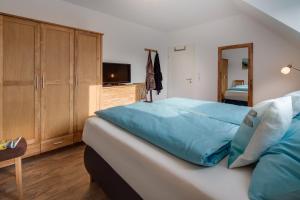 a bedroom with a bed with blue sheets and a mirror at Louise am Meer in Norderney