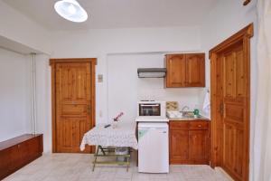 eine kleine Küche mit einem Tisch und einer Mikrowelle in der Unterkunft Elsa Stafilos in Skopelos