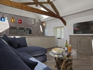 a living room with a blue couch and a table at The Barn, 20 At The Beach in Beesands