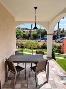 a dining table and chairs on a patio at HomeStyle Agorà in Villasimius