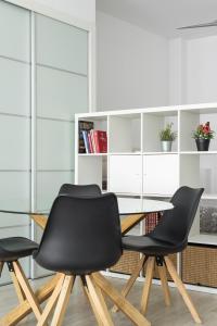 a dining room with a glass table and two black chairs at Charming Loft A in Málaga