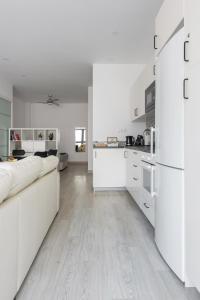 a white kitchen with white appliances and a white couch at Charming Loft A in Málaga
