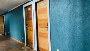 un pasillo con 2 puertas de madera y paredes azules en 8 Habitación Privada - Cama Matrimonial, en Puerto Varas