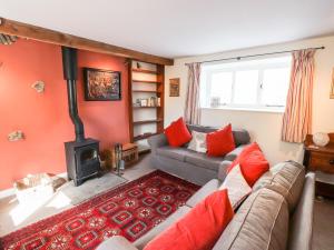 uma sala de estar com um sofá e um fogão em One Town End em Penrith