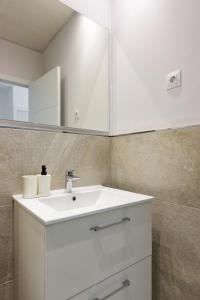 a bathroom with a white sink and a mirror at Charming Loft A in Málaga