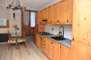 una cocina con armarios de madera y fregadero en Apartamento Rústico-moderno 4 plazas Accesible-Adaptado Pobla de Lillet, en La Pobla de Lillet