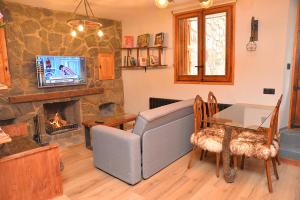 sala de estar con sofá y chimenea en Apartamento Rústico-moderno 4 plazas Accesible-Adaptado Pobla de Lillet, en La Pobla de Lillet