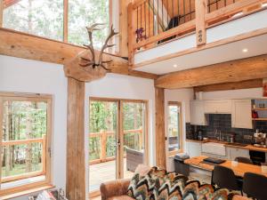 a large living room with wooden ceilings and windows at Pine Marten Lodge in Grantown on Spey