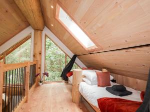 a bedroom in a tiny house with a skylight at Pine Marten Lodge in Grantown on Spey