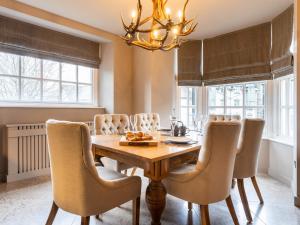 mesa de comedor con sillas y lámpara de araña en Prospect House, en Windermere