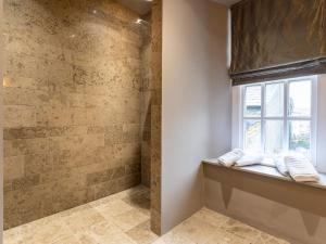 baño con ventana y ducha con toallas en Prospect House, en Windermere
