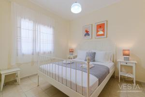 a white bedroom with a bed and two tables at Green Gem Apartments with 2 bdrms, Afytos in Afitos