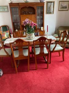 una mesa de comedor con un jarrón de flores. en Rose Cottage en Prestwick