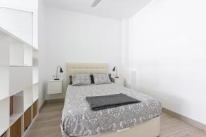 um quarto branco com uma cama e paredes brancas em Charming Loft A em Málaga