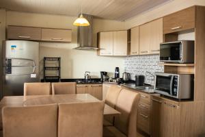 a kitchen with a table and a microwave at TOLEDO'S HOUSE in São Francisco de Paula