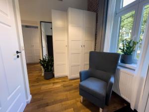 URBAN APARTMENTS PREMIUM Poniatowskiego 23 No 4 Chorzów Katowice FREE PUBLIC PARKING في شورزوف: غرفة معيشة مع كرسي ونافذة