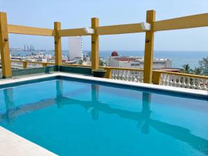 a swimming pool on the roof of a building with the ocean in the background at Howard Johnson by Wyndham Veracruz in Veracruz