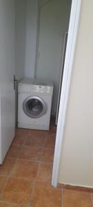 een wasmachine en droger in een kleine kamer bij Pitsinis Apartments II in Roda