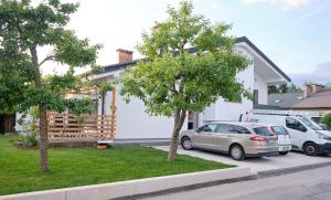 uma casa com dois carros estacionados num parque de estacionamento em Apartma La Casa em Radovljica