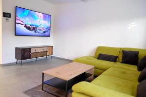 a living room with a couch and a tv on the wall at Apartma La Casa in Radovljica