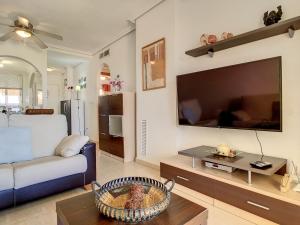 a living room with a couch and a large flat screen tv at Ribera Beach 2 - 1106 in Mar de Cristal