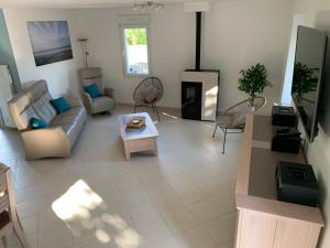 a living room with a couch and a table at BlackBerry Cottage - Maison de vacances - with WIFI in Lessay
