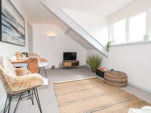 an attic living room with white walls and windows at The Nest in Dartmouth