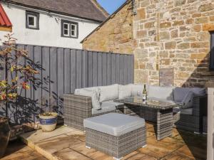 a patio with a couch and a table and a fence at Stanley Barn in Brampton