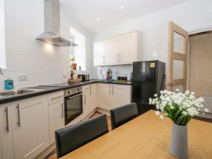 cocina con mesa de madera y nevera negra en Neland View en Windermere