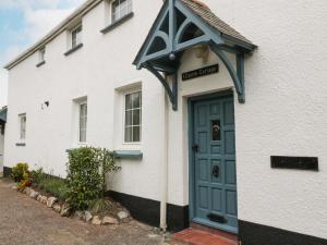 un edificio blanco con una puerta azul delante de él en 1 Castle Cottages en Exeter