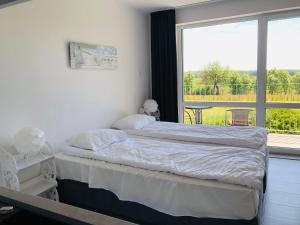 a bedroom with a bed and a large window at Sea Power Horyzont Apartament 9 in Jastrzębia Góra