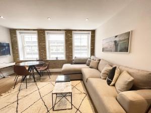 a living room with a couch and a table at Covent Garden & Drury lane Apartments in London