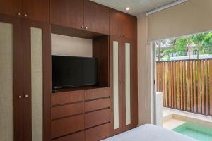 - une chambre avec une télévision à écran plat dans une armoire dans l'établissement 1BR Apartment with Private Pool and Rooftop Access Tulum A103, à Tulum