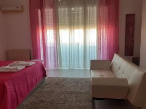 ein Wohnzimmer mit einem Sofa und rosa Vorhängen in der Unterkunft Olbia Center House in Olbia