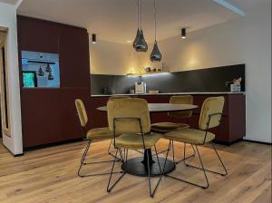 een keuken en eetkamer met een tafel en stoelen bij La Perla - 2 Zimmer Designer Wohnung in Klosters
