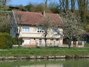 a house with a red roof next to a river at Gîte Vilosnes-Haraumont, 4 pièces, 5 personnes - FR-1-585-82 