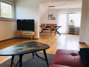 sala de estar con TV y mesa en Schöne Ferienwohnung mit viel Platz und Parkplatz, en Müllheim