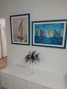 a white counter with a vase of flowers and paintings at Central Apartment Bella in Split