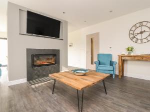a living room with a table and a fireplace at Laundry Cottage in Milnthorpe