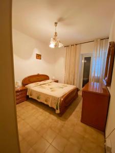 sypialnia z łóżkiem i żyrandolem w obiekcie La dimora Difenza w mieście Vasto