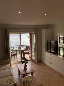 a living room with a couch and a kitchen with a table at Apartments Plazs 41 in Sukošan
