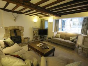a living room with a couch and a fireplace at Butlers Cottage in Burford