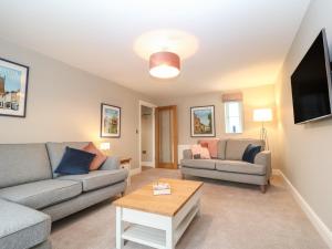 a living room with two couches and a tv at 9 Windrush Heights in Burford