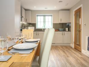 a kitchen and dining room with a wooden table at 9 Windrush Heights in Burford