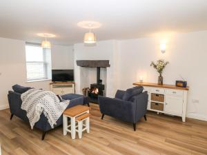 a living room with two chairs and a fireplace at 2 Rhoslyn in Caernarfon