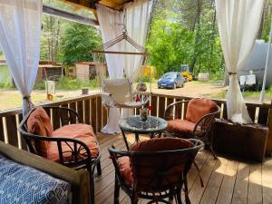 a porch with chairs and a table on a deck at Караваната На Морето in Sozopol