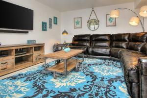 a living room with a leather couch and a flat screen tv at Reef Club 107 in Clearwater Beach